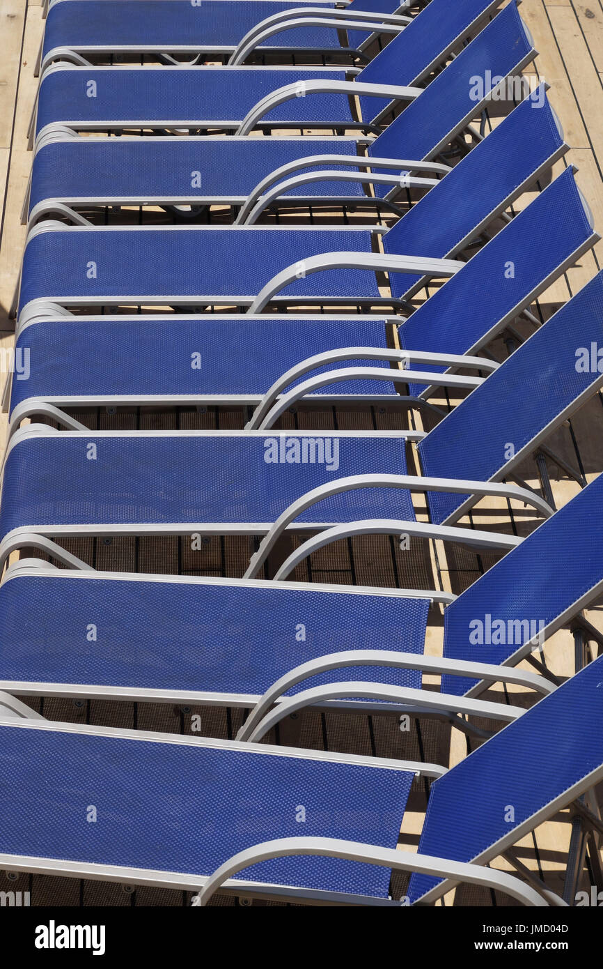 Sedie a sdraio schierate dalla piscina su una nave da crociera Foto Stock