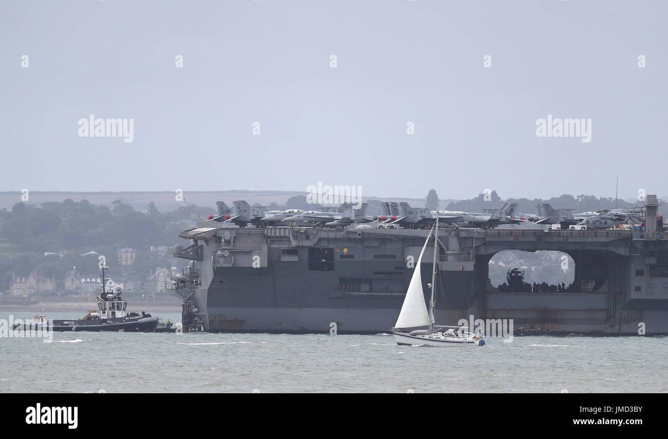 Una barca a vela passa la US Navy Nimitz-class portaerei USS George H.W. Bush come si stabilisce al di ancoraggio fuori coastbefore partecipa n esercizio guerriero sassone 2017 nel Nord dell'Oceano Atlantico. Foto Stock