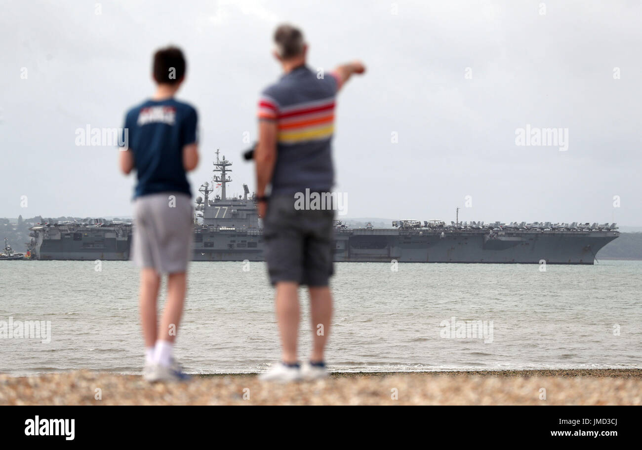 Le persone si affacciano alla US Navy Nimitz-class portaerei USS George H.W. Bush come si stabilisce al di ancoraggio fuori coastbefore partecipa n esercizio guerriero sassone 2017 nel Nord dell'Oceano Atlantico. Foto Stock