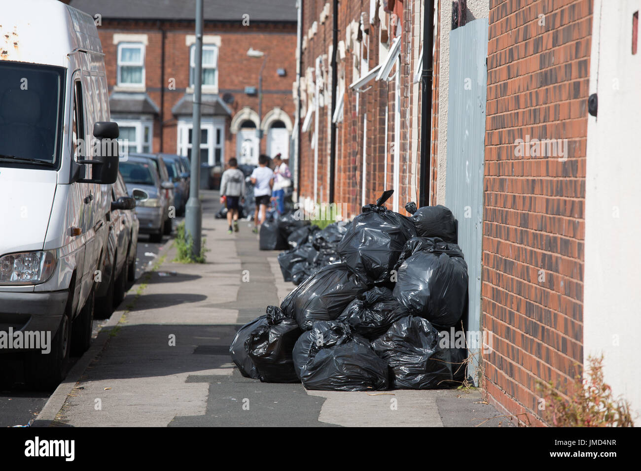 Cumuli di rifiuti non riscossi in strada catramosi, allume Rock, Birmingham. I raccoglitori di rifiuti sono in sciopero per protestare contro i tagli del personale e un salario inferiore Foto Stock