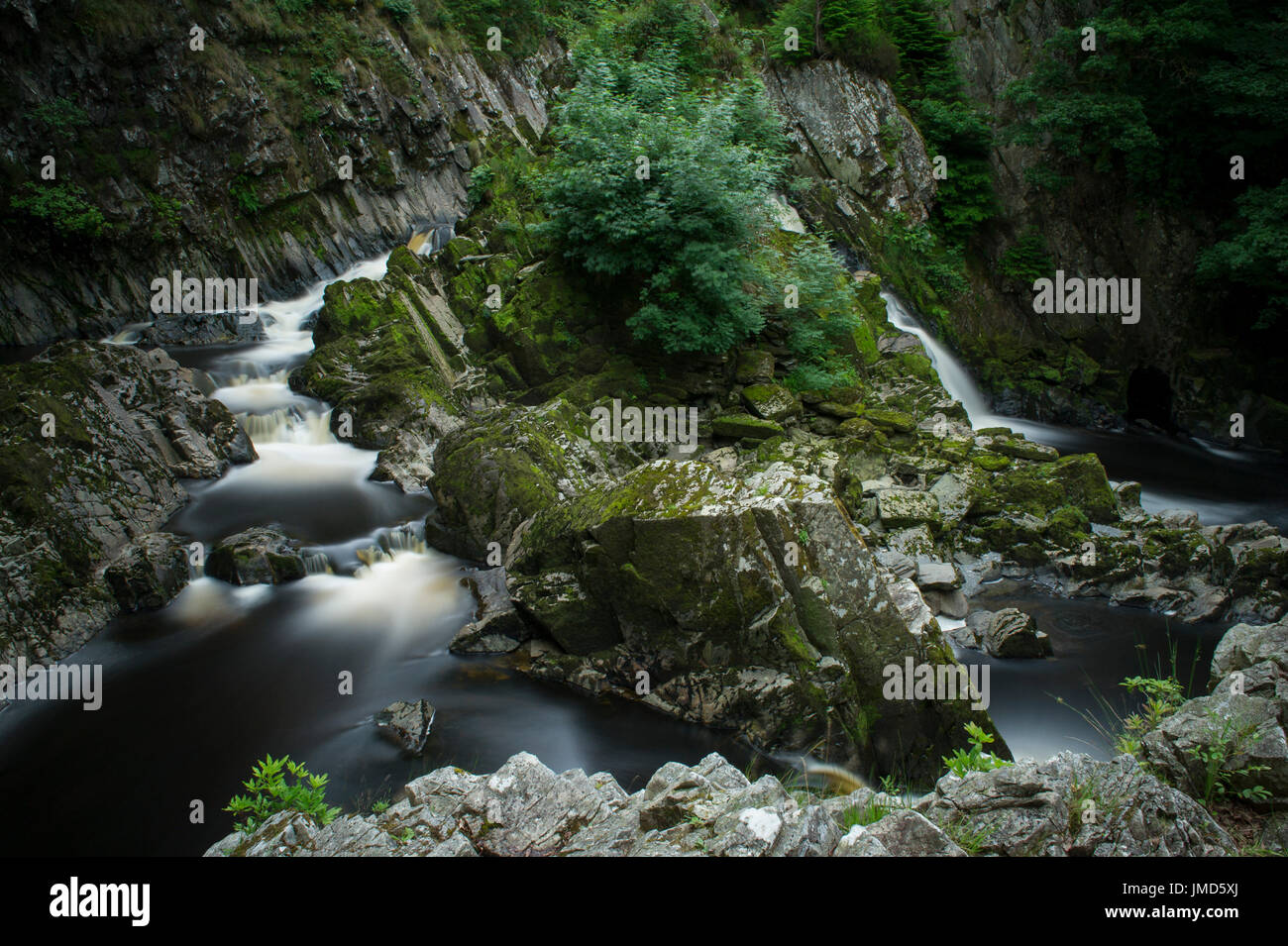 Una lunga esposizione della bella Conwy Falls cascate del Parco Nazionale di Snowdonia, Galles Foto Stock