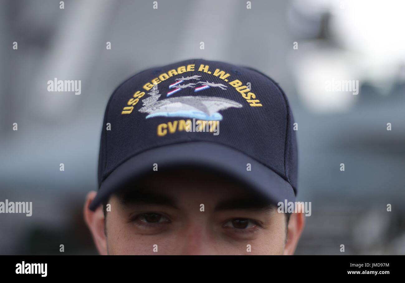 Un membro di equipaggio indossa un cappello a bordo della US Navy Nimitz-class portaerei USS George H.W. Bush come si stabilisce al di ancoraggio al largo prima di esso partecipa in esercizio guerriero sassone 2017 nel Nord dell'Oceano Atlantico. Foto Stock