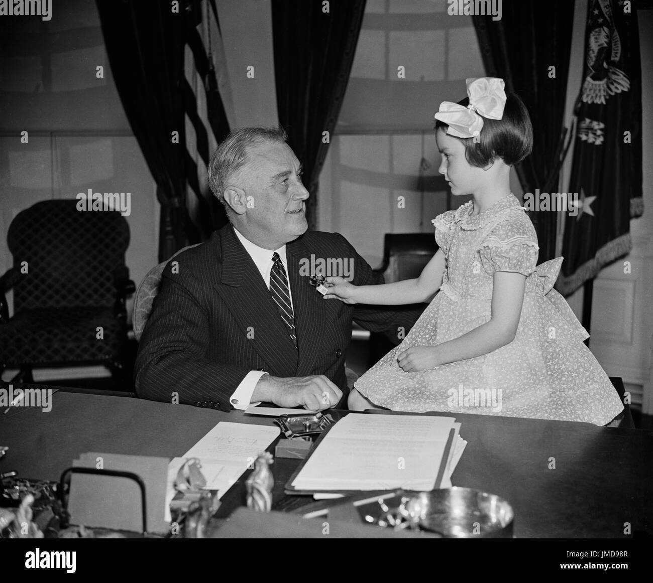 Stati Uniti Il presidente Franklin Roosevelt viene presentato con la prima Buddy Papavero delle nazionali annuali di vendita di papavero da 6-year-old Jane Colgan, con vendite dedicata al benessere degli animali e di soccorso per i veterani e le loro famiglie, la Casa Bianca a Washington DC, USA, Harris & Ewing, 14 aprile 1938 Foto Stock