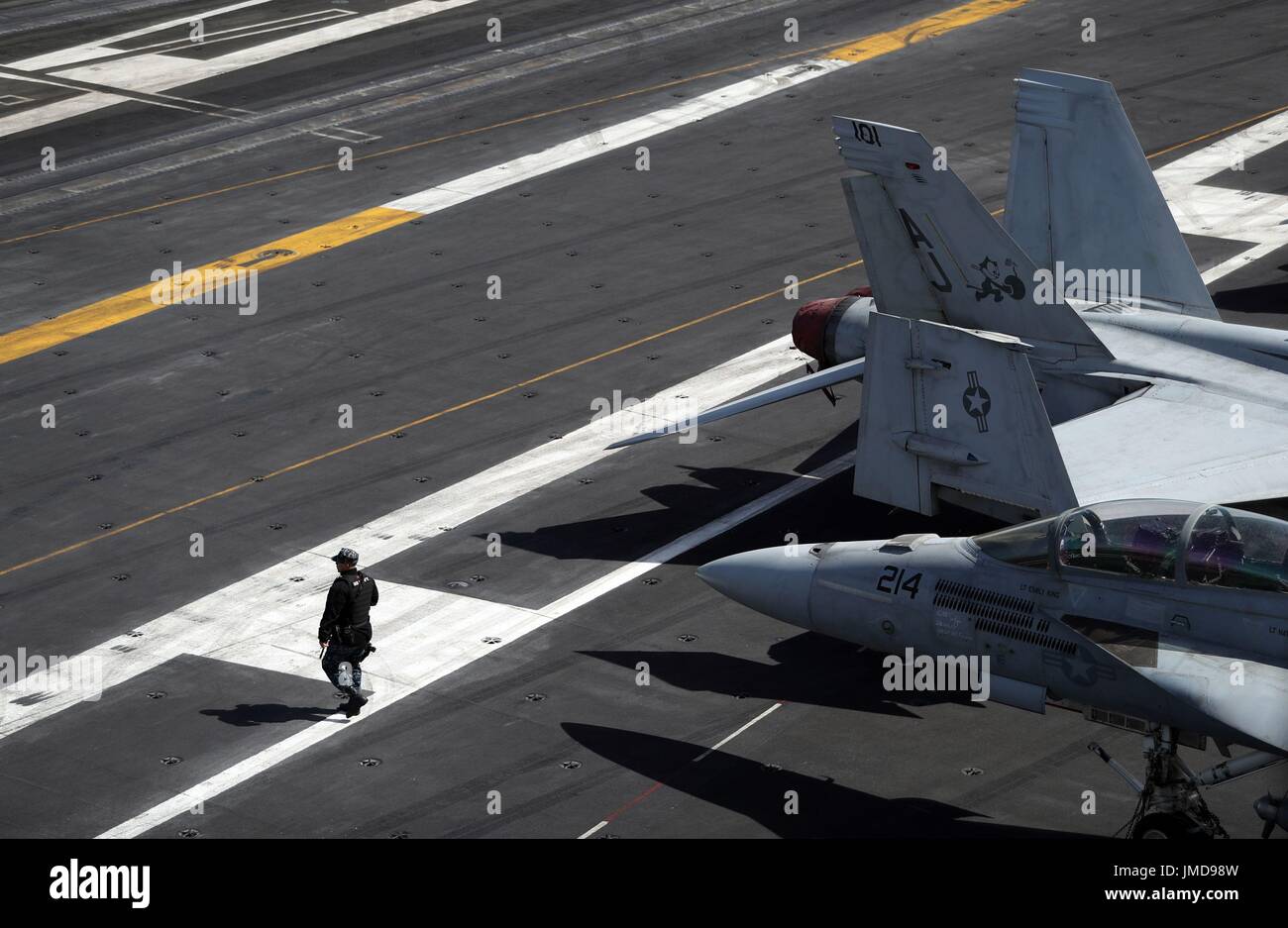 Un membro di equipaggio passeggiate passato 2 F-18 getti a bordo della US Navy Nimitz-class portaerei USS George H.W. Bush come si stabilisce al di ancoraggio al largo prima di esso partecipa in esercizio guerriero sassone 2017 nel Nord dell'Oceano Atlantico. Foto Stock