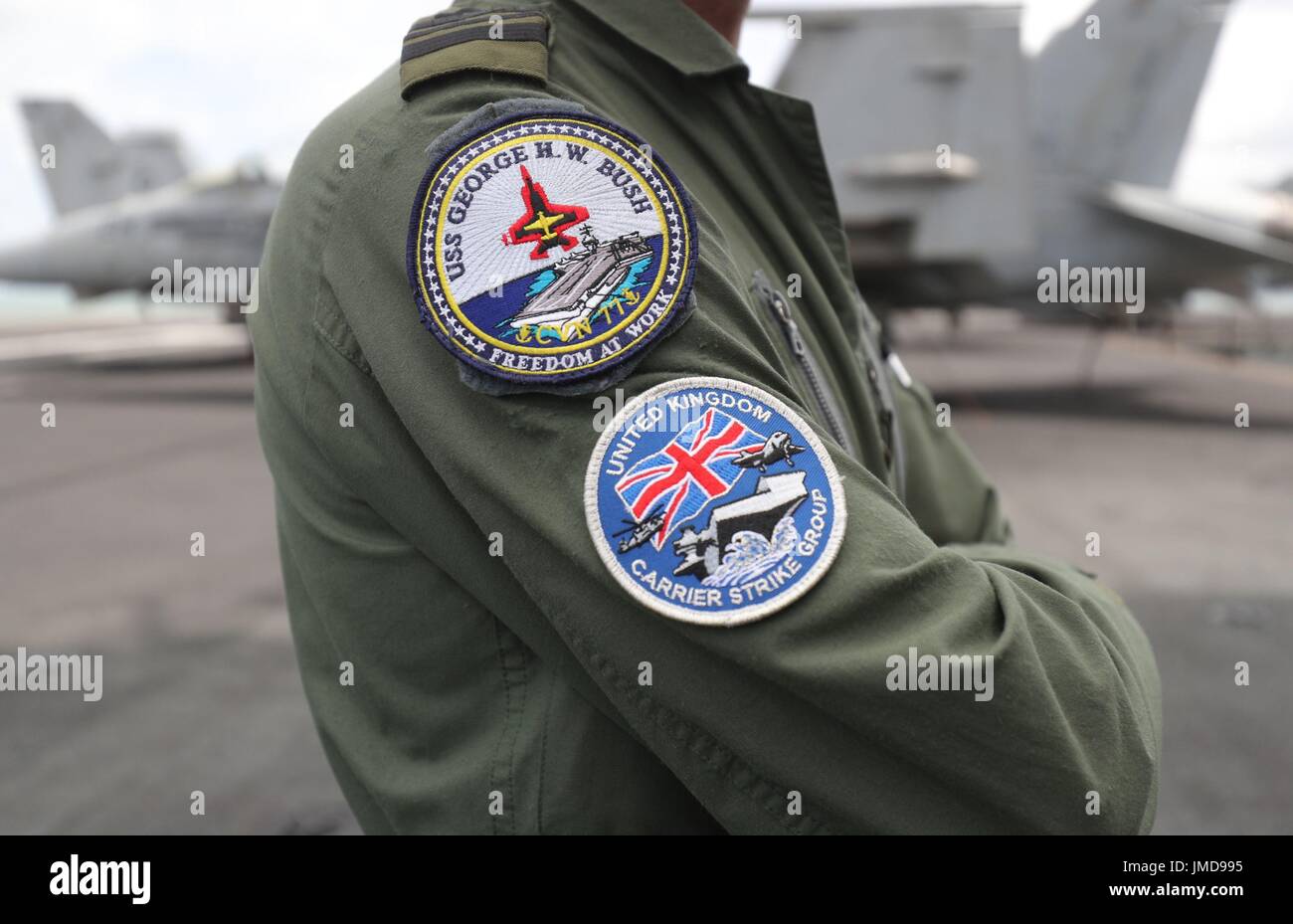 Scudetti sul manicotto della Royal Navy il Tenente Comandante James Capps a bordo della US Navy Nimitz-class portaerei USS George H.W. Bush come si stabilisce al di ancoraggio al largo prima di esso partecipa in esercizio guerriero sassone 2017 nel Nord dell'Oceano Atlantico. Foto Stock