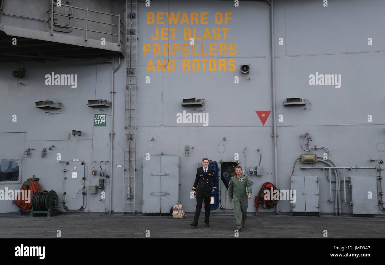 Commodore Andrew Betton (destra) walsk fuori per chattare con i membri dei media a bordo della US Navy Nimitz-class portaerei USS George H.W. Bush come si stabilisce al di ancoraggio al largo prima di esso partecipa in esercizio guerriero sassone 2017 nel Nord dell'Oceano Atlantico. Foto Stock