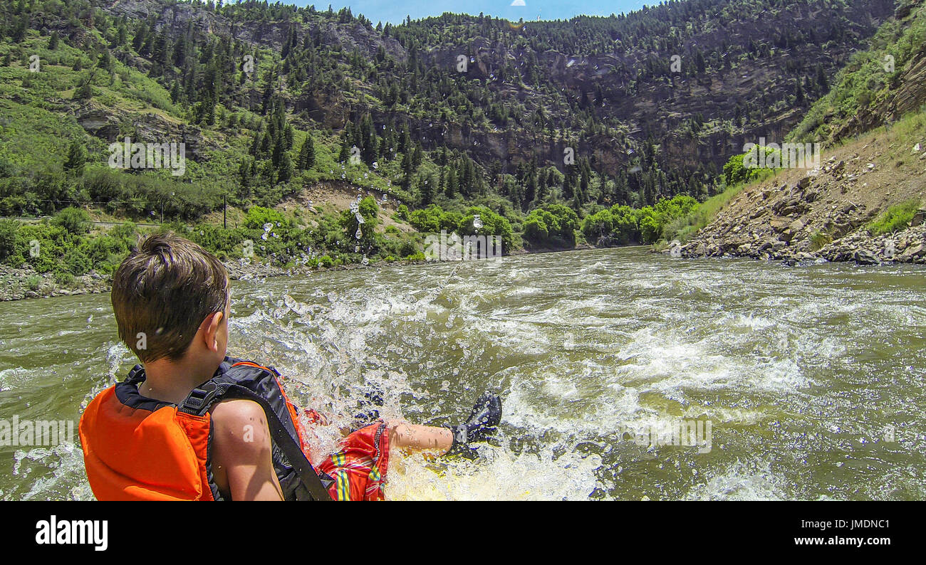 Un giovane ragazzo corse il toro durante un white water rafting expedition sul fiume Colorado in Glenwood Canyon Foto Stock