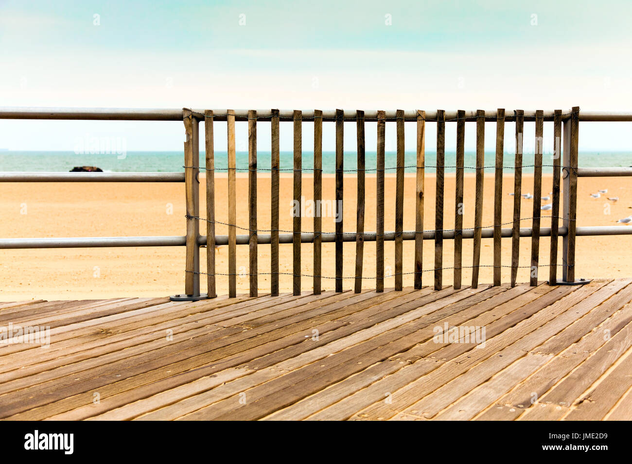 Il Boardwalk, svuotare la spiaggia e l'oceano. Picchetti in legno ringhiera. Vista verso l'acqua. Retro Vintage colore. Coney Island Foto Stock