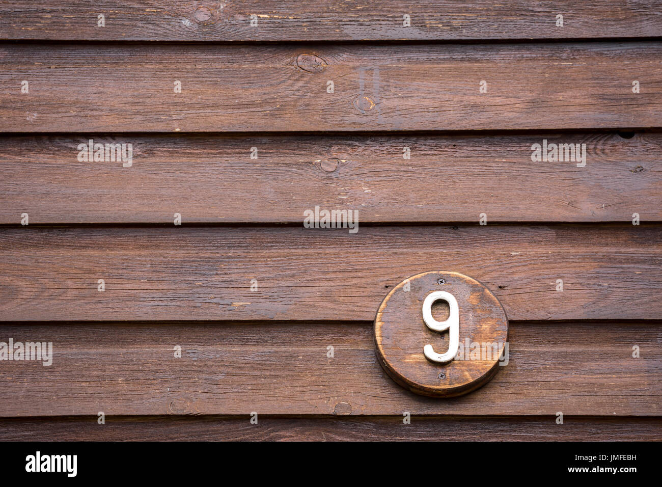 Cartello stradale su una casa la lettura del numero nove di legno Foto Stock