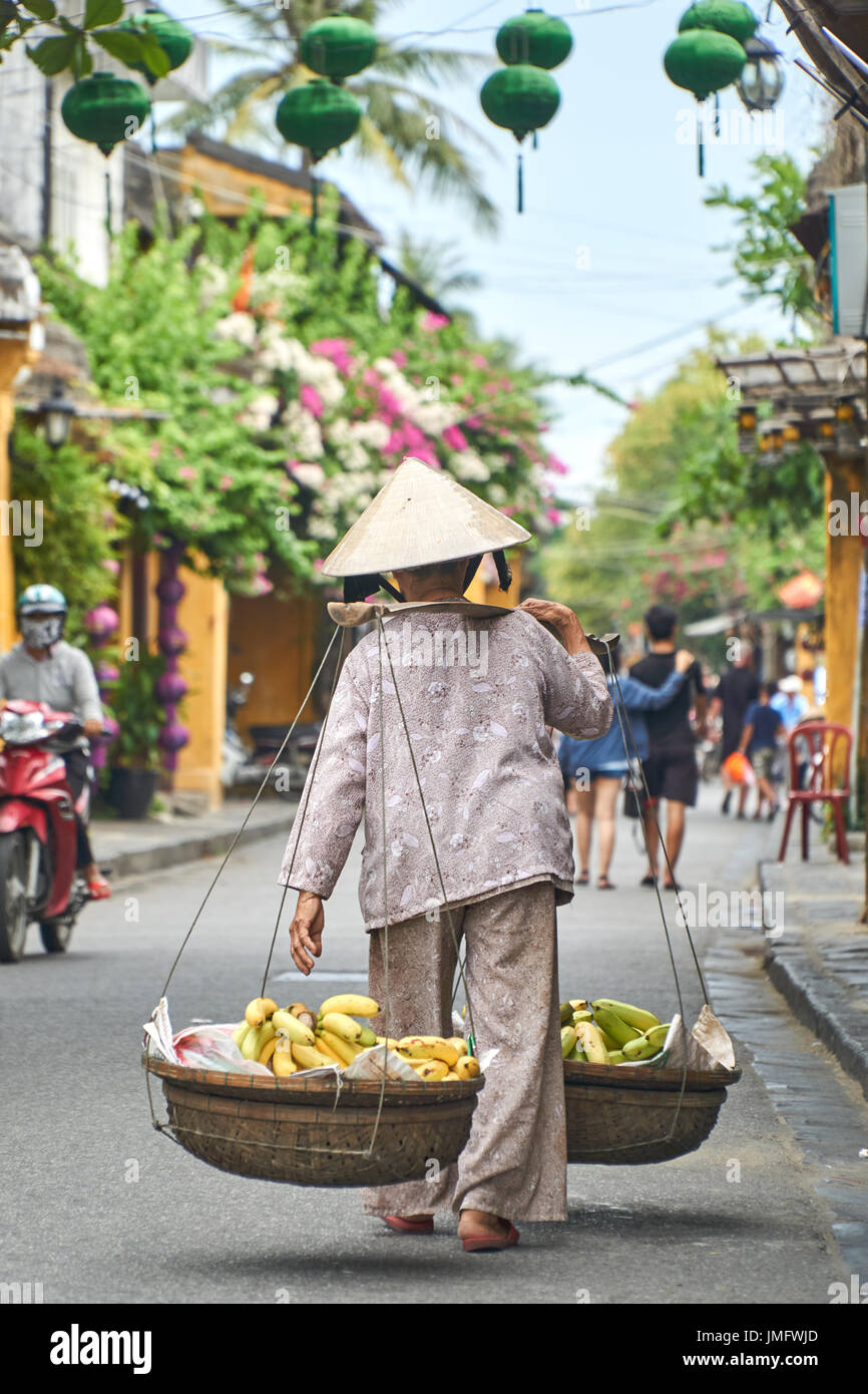 Irriconoscibile tradizionali di banane fornitore di frutta da dietro in Hoi An, Vietnam. Foto Stock