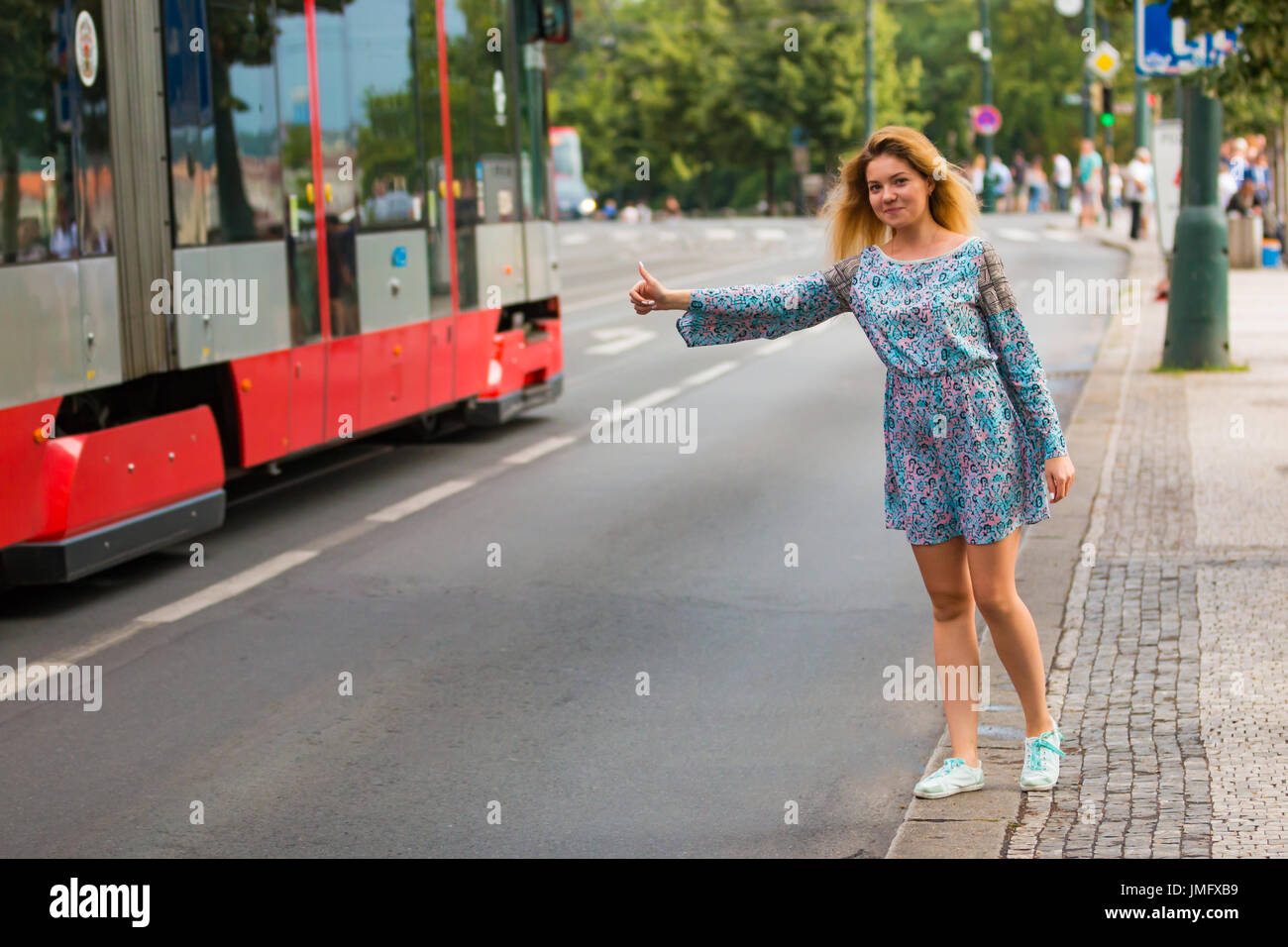 Giovane donna facendo il sollevatore-escursionismo in una strada di una città Foto Stock