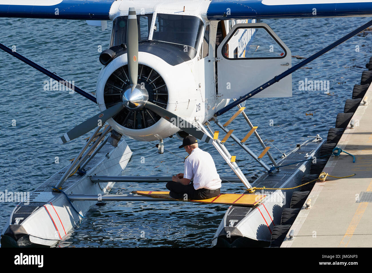 Pilot si siede sui galleggianti del suo de Havilland Beaver idrovolanti nel porto di Vancouver, British Columbia, Canada. Foto Stock