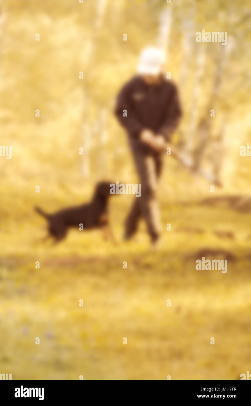 Abstract immagine sfocata della natura e l'uomo con un cane in una passeggiata per utilizzare lo sfondo. Foto Stock