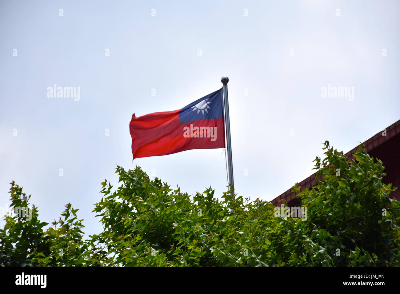 Bandiera di Taiwan al vento sopra gli alberi, in Taipei, Taiwan. Foto Stock