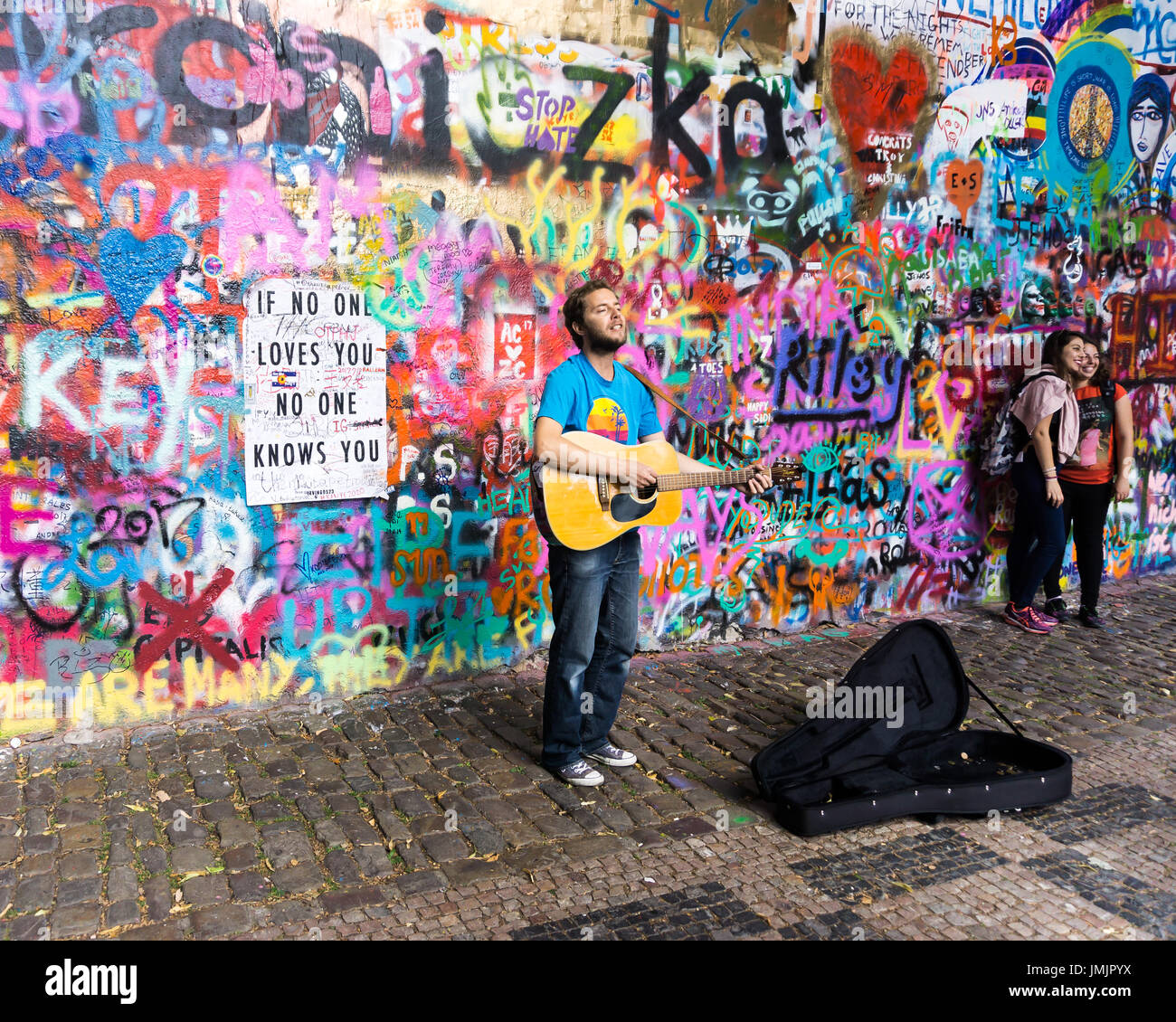 Musicista riproduce brani alla chitarra dalla parete di Lennon in Praga. Foto Stock
