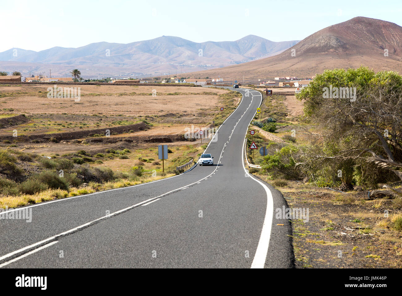 Su strada asfaltata attraversando la campagna, Tefia, Fuerteventura, Isole Canarie, Spagna Foto Stock