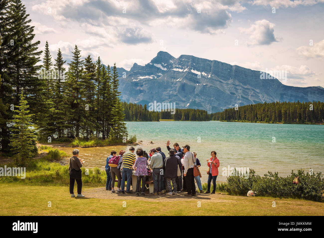 Gruppo di turisti asiatici di pranzare in due jack lago nel Parco Nazionale di Banff con Mt. Rundle in background. Foto Stock