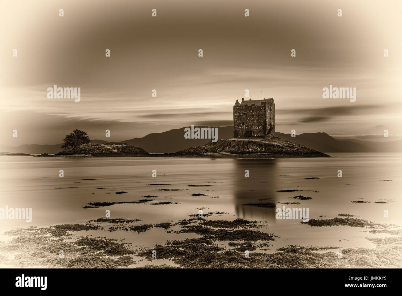 Sunset over Castle Stalker, Highlands, Scotland, Regno Unito. Vintage in bianco e nero elaborata. Foto Stock