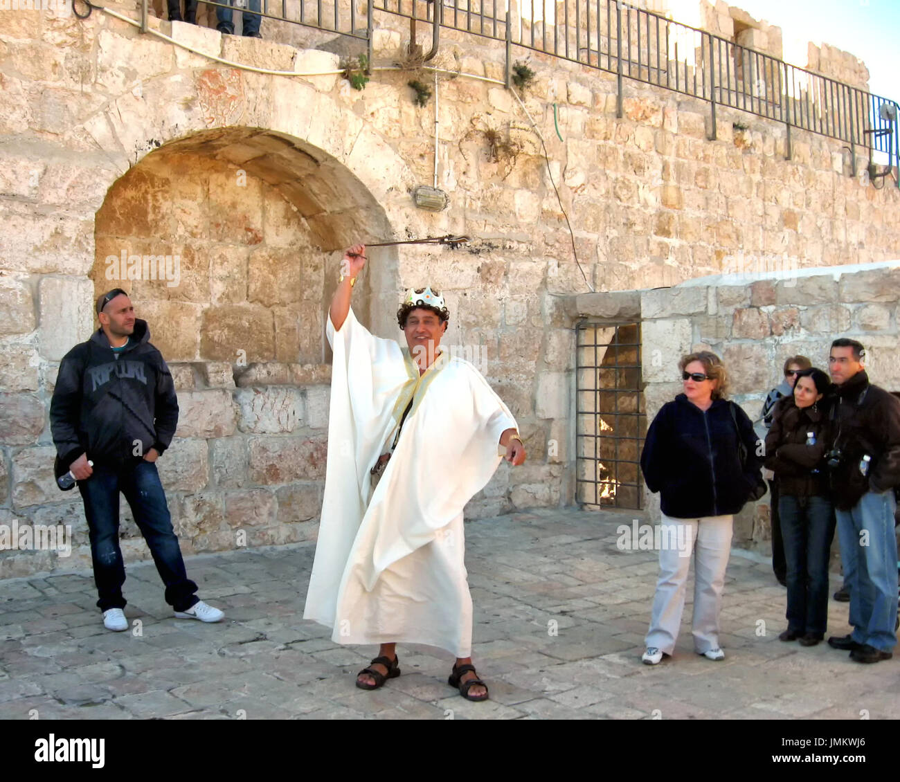 Un attore raffigura il re Davide per un gruppo di persone su Gerusalemme bastioni della città vecchia parete. Foto Stock