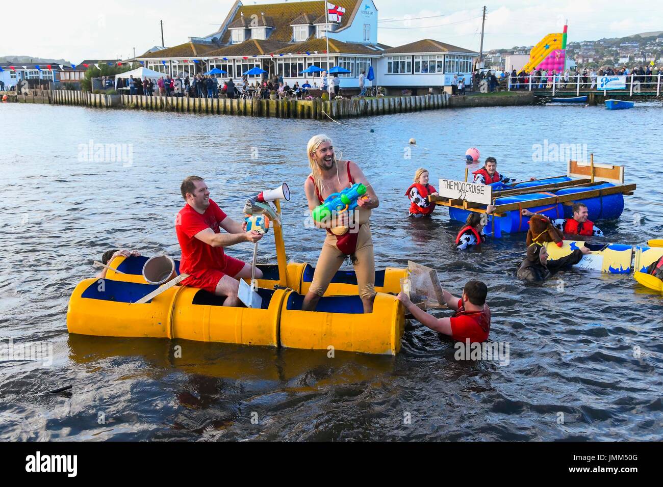 West Bay, Dorset, Regno Unito. Il 27 luglio 2017. RNLI annuale gara zattera sul fiume Brit alla stazione balneare di West Bay nel Dorset. I concorrenti spruzzare la folla a guardare la gara con le pistole ad acqua. Credito Foto: Graham Hunt/Alamy Live News Foto Stock