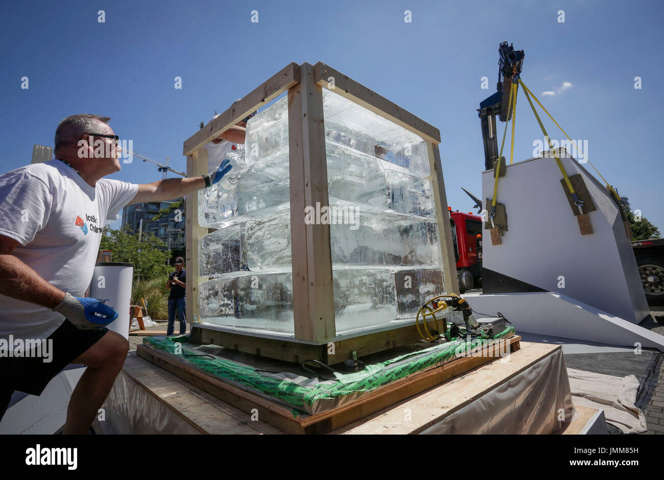 Vancouver, Canada. 27 Luglio, 2017. Lavoratori pila di blocchi di ghiaccio durante l'Ice Box sfida in Vancouver, Canada, 27 luglio 2017. L'Ice Box Challenge è un esperimento pubblico per dimostrare i vantaggi del super edifici efficienti dal punto di vista energetico sotto la casa passiva costruzione standard. Due piccole di casa-come scatole costruita con standard di casa passiva e i codici di costruzione locali specifiche seduti fianco a fianco in una zona aperta per 18 giorni con una tonnellata di blocco di ghiaccio racchiusi per testimoniare il nuovo zero emission building standard. Credito: Liang sen/Xinhua/Alamy Live News Foto Stock