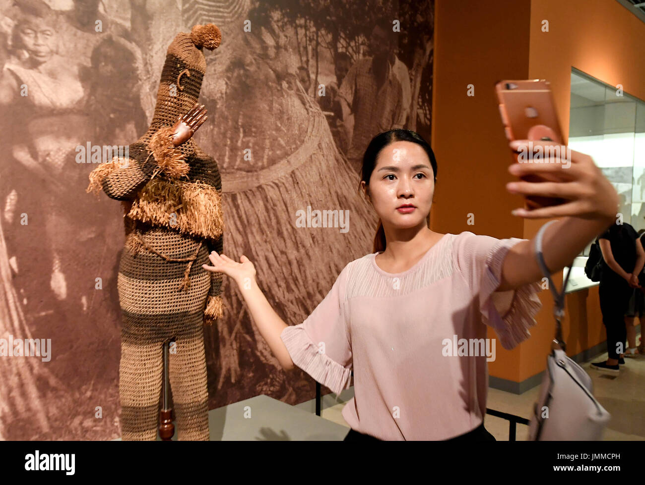 Zhengzhou, la Cina della Provincia di Henan. 28 Luglio, 2017. Un visitatore assume un selfie con esibizioni al "Dio di foresta pluviale--China-Africa maschere rare Exhibition" nella Città di Zhengzhou, capitale della Cina centrale della Provincia di Henan, 28 luglio 2017. La mostra è stata ospitata dal Museo di Henan ed è stato aperto al pubblico il venerdì. Più di 130 presenta sul display ha dimostrato la diversità, la creatività e la fantasia delle arti africane e della civiltà. La mostra resterà aperta fino al 8 ottobre. Credito: Li Un/Xinhua/Alamy Live News Foto Stock