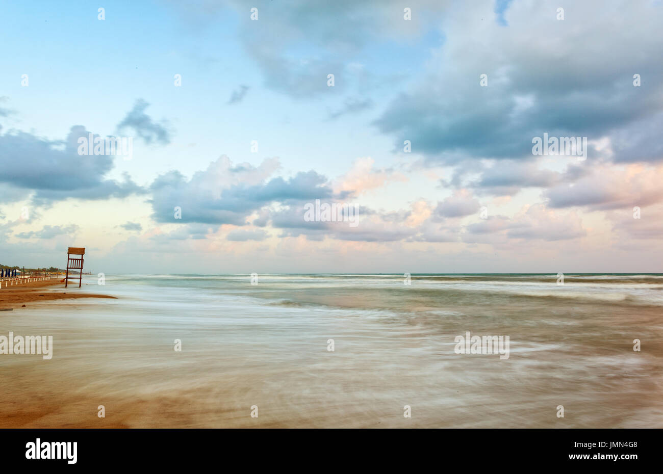 Paesaggio di spiaggia con mare mosso e il legno della torre di vedetta Foto Stock