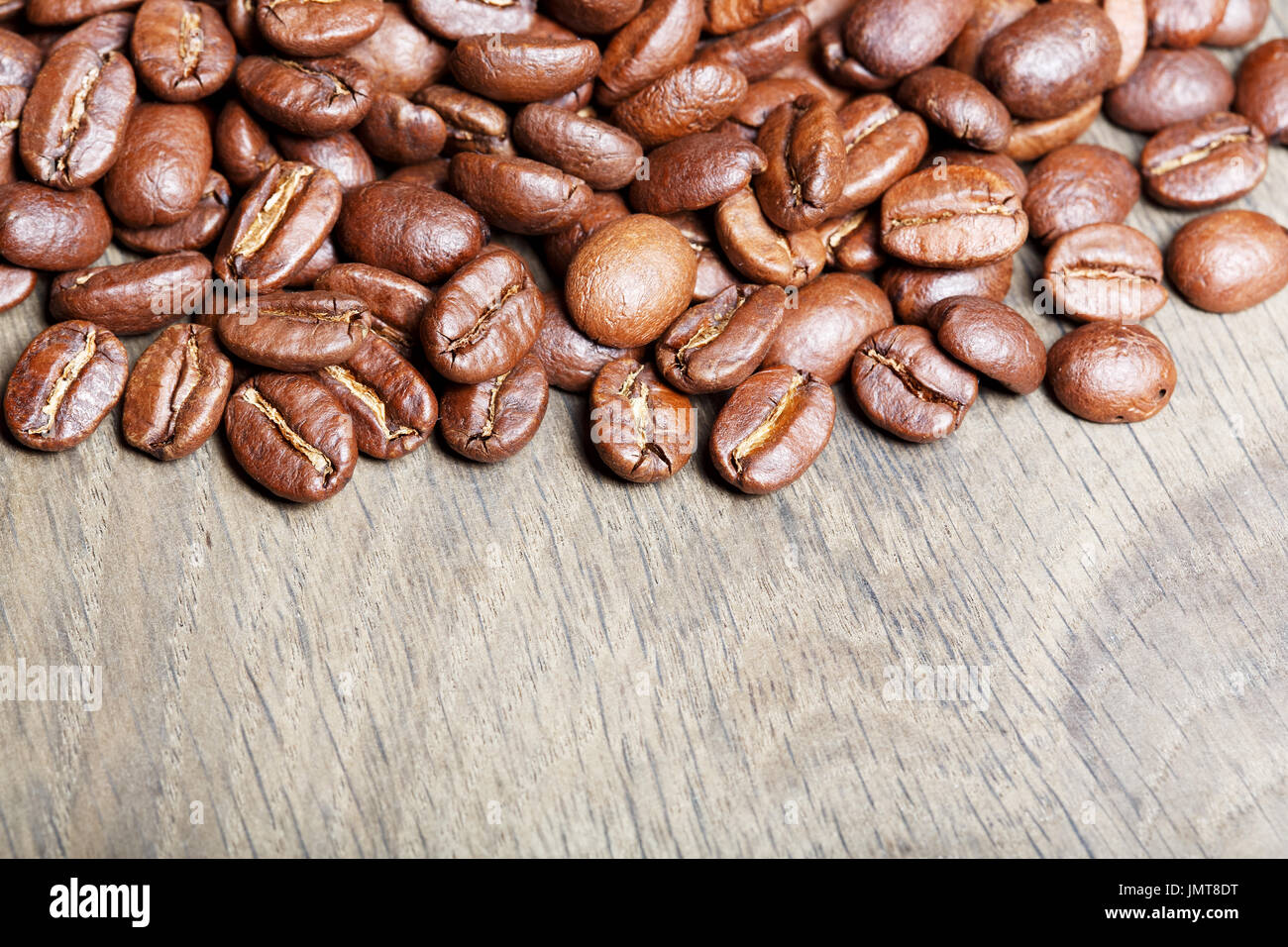 Naturale di fresco il caffè torrefatto in grani oltre a trama backgr in legno Foto Stock