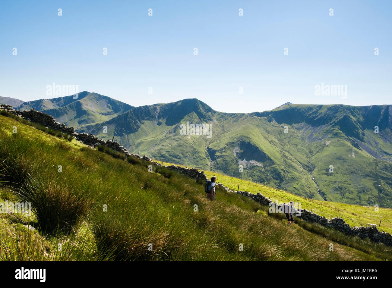 Gli escursionisti escursionismo giù Carnedd Dafydd in montagna Carneddau montagne del Parco Nazionale di Snowdonia. Y Garn Foel Goch e Mynydd Perfedd sulla skyline. Regno Unito Foto Stock