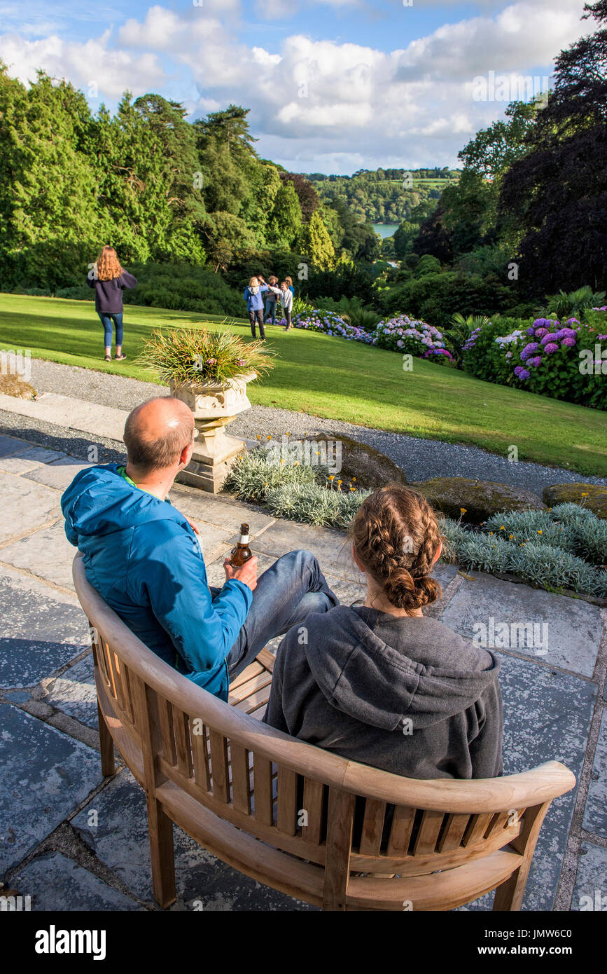 Persone e rilassante godendo la vista sul sub-tropicale giardino Trebah in Cornovaglia. Foto Stock