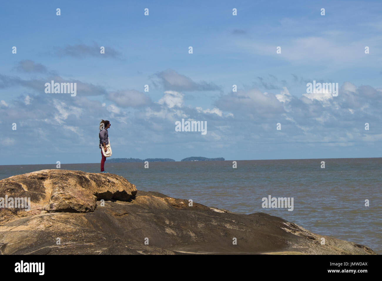 Un uomo in piedi su una roccia sullo sfondo della salvezza's islands a Kourou (Guiana francese Foto Stock