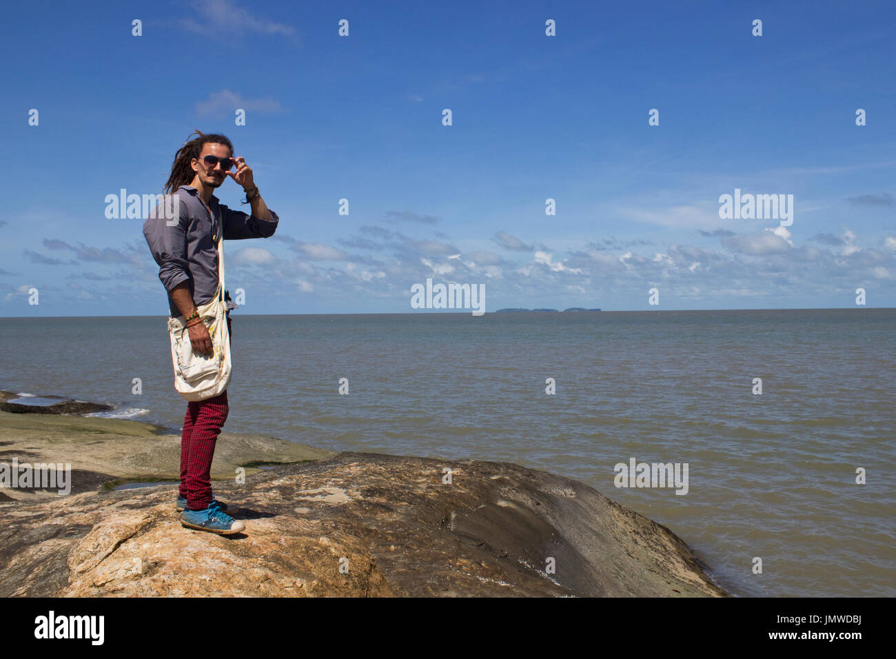 Un uomo in piedi su una roccia sullo sfondo della salvezza's islands a Kourou (Guiana francese Foto Stock