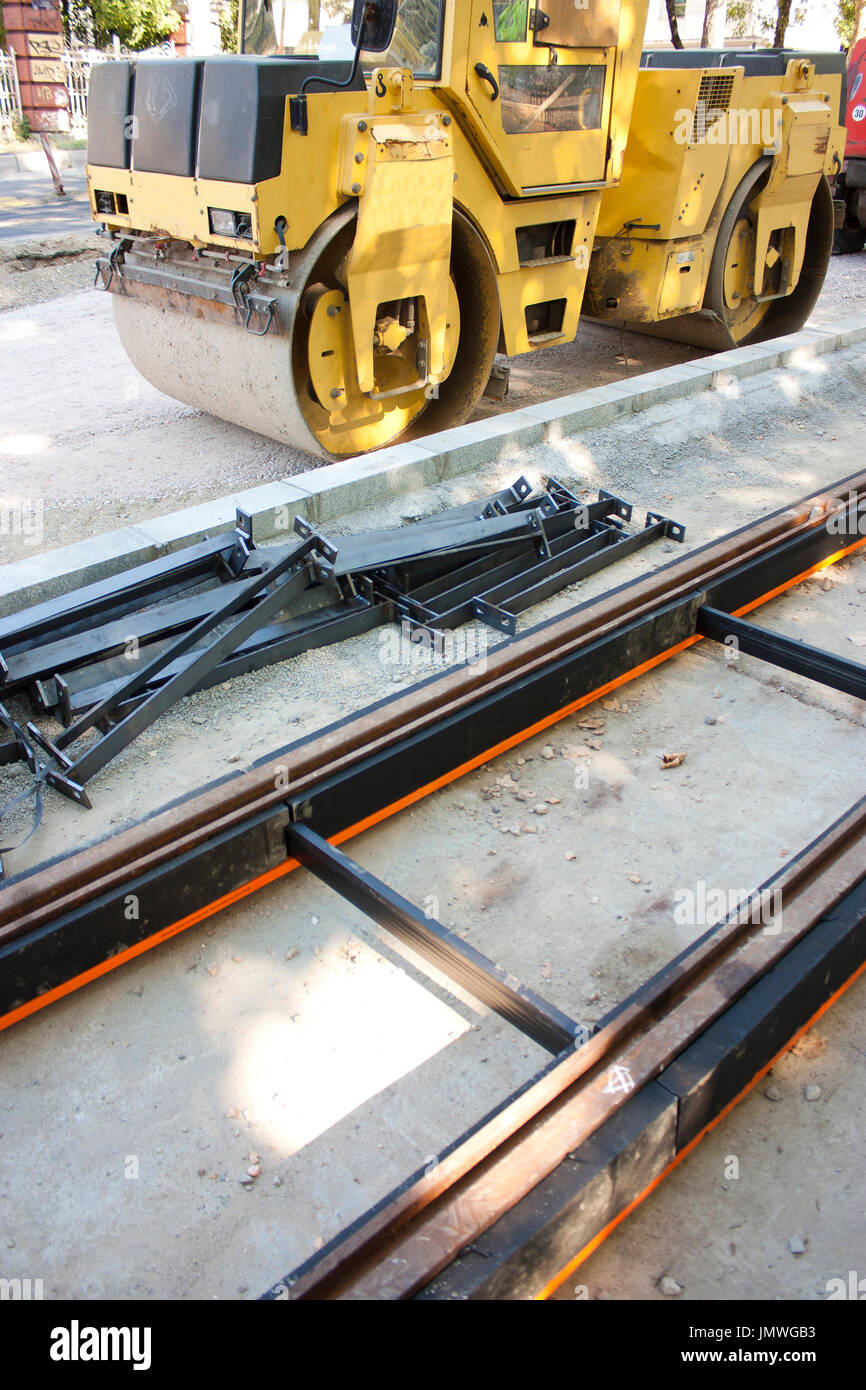 Strada di città tronchi ferroviari per i tram, strada in acciaio rullo di tamburo una strada facendo ingegneria veicolo utilizzato per terreni compatti nel settore della costruzione Foto Stock