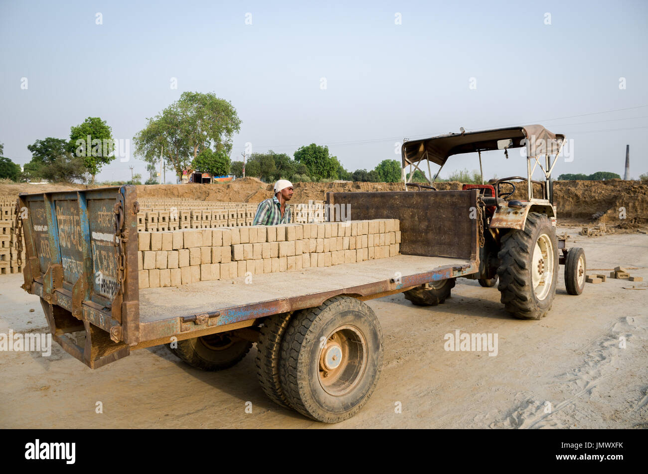 Amritsar Punjab, India - 21 aprile 2017 : mattoni essendo caricati su un carrello da un lavoratore pronto per la spedizione a un mercato all'ingrosso Foto Stock