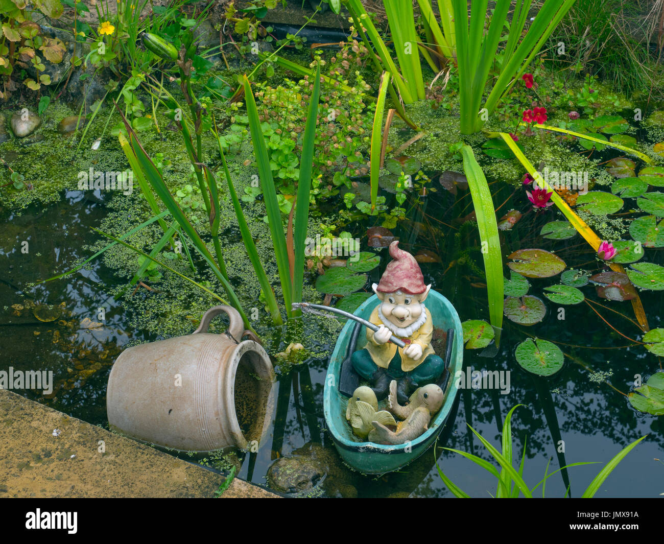 Giardino gnome di Pesca nel laghetto in giardino Foto Stock
