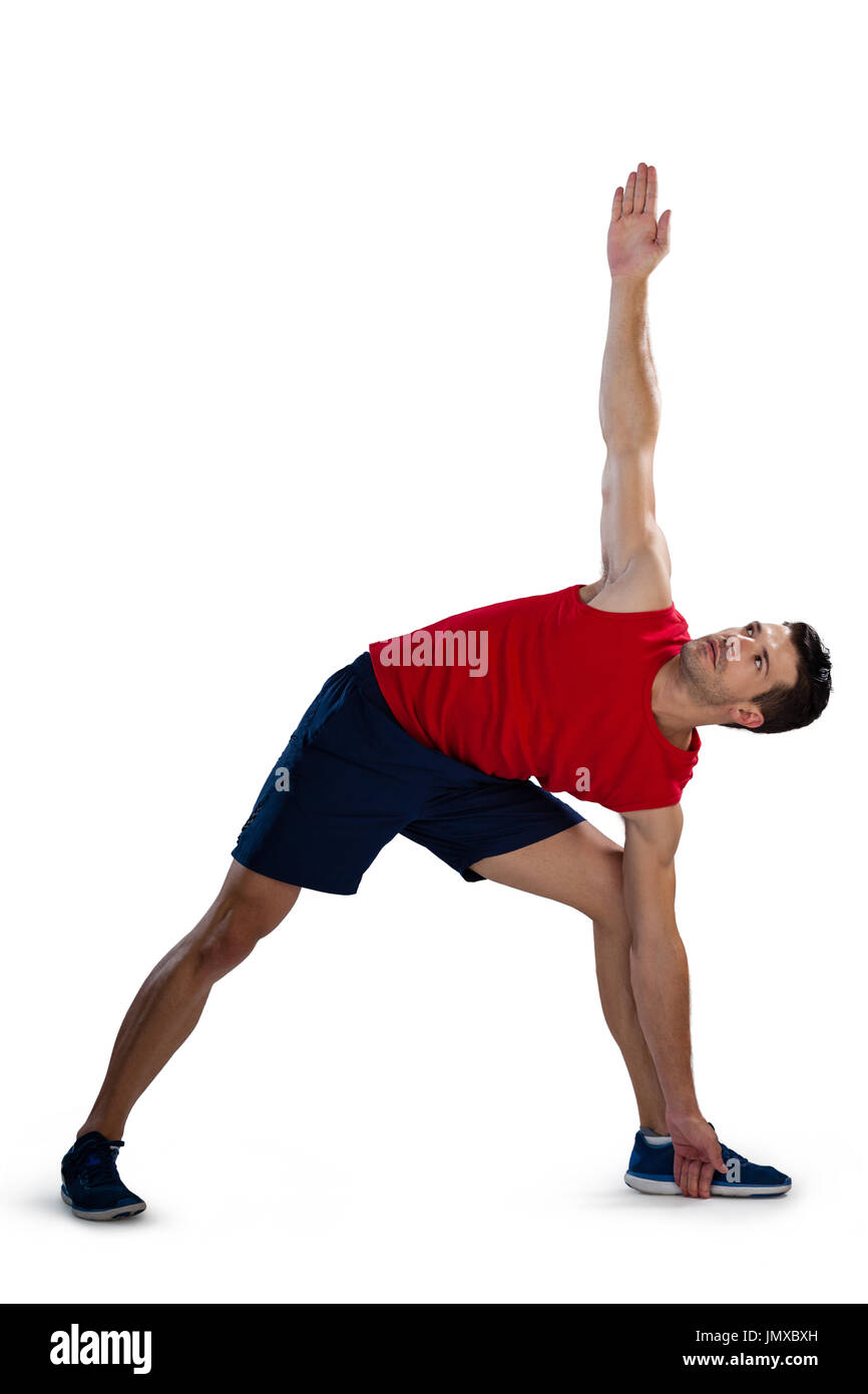 Determinati sport player esercitando con la mano alzata mentre piegando contro uno sfondo bianco Foto Stock