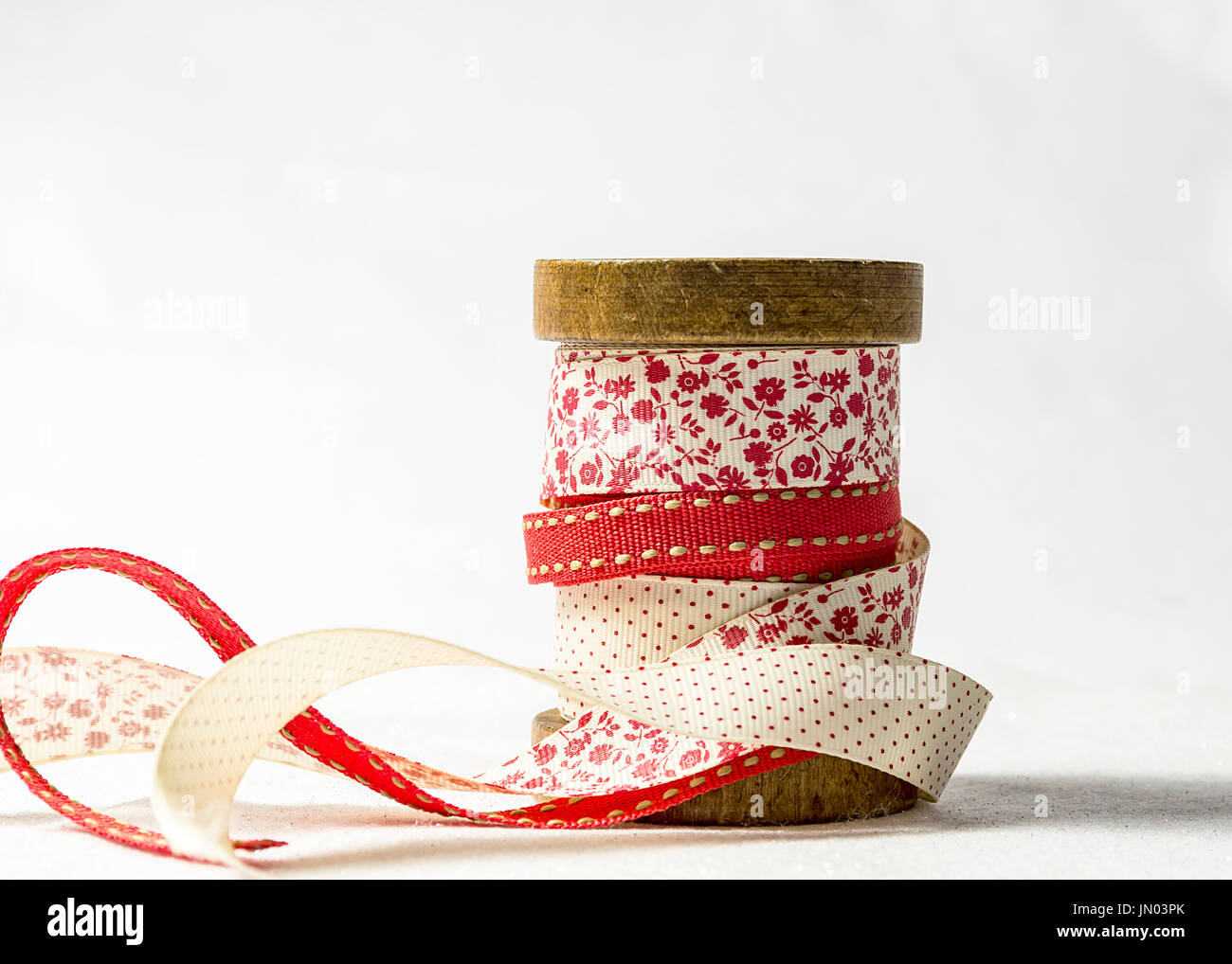 Selezione dei nastri avvolti attorno ad un rocchetto di legno per Natale confezione regalo Foto Stock