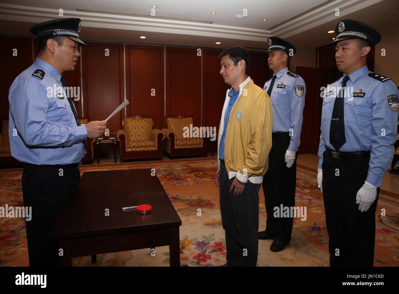 (170729) -- PECHINO, luglio 29, 2017 (Xinhua) -- un poliziotto legge un mandato di arresto per Ren Biao all'Aeroporto Internazionale Capital di Pechino a Pechino Capitale della Cina, 29 luglio 2017. Ren Biao, uno della Cina il più voluto fuggiaschi, ha restituito alla Cina e si voltò alla polizia, l'anti-corruzione competente detto sabato. Ren, 44, ex " controllo effettivo " azionista di Daluo le forniture di energia società in oriente cinese della provincia di Jiangsu, fuggiti nella nazione caraibica di Saint Kitts e Nevis nel gennaio 2014 dopo essere stato accusato di aver fraudolentemente ottenimento di prestiti e di fabbricare bil finanziario Foto Stock