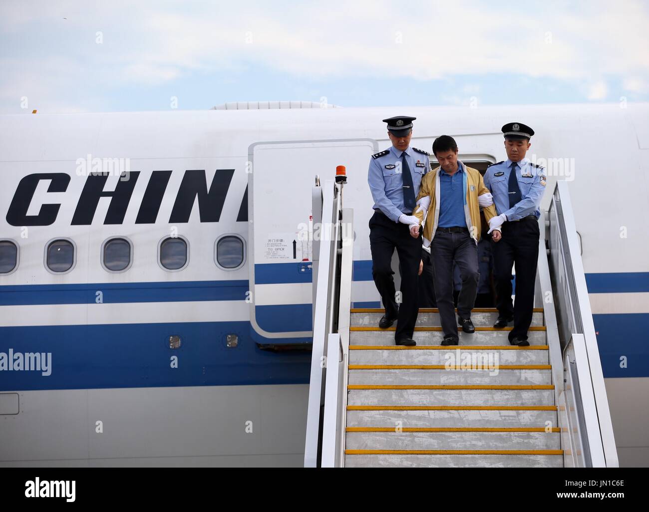 (170729) -- PECHINO, luglio 29, 2017 (Xinhua) -- Ren Biao (C), approda a partire da un piano sotto scorta di polizia presso il Beijing Capital International Airport di Pechino, capitale della Cina, 29 luglio 2017. Ren Biao, uno della Cina il più voluto fuggiaschi, ha restituito alla Cina e si voltò alla polizia, l'anti-corruzione competente detto sabato. Ren, 44, ex " controllo effettivo " azionista di Daluo le forniture di energia società in oriente cinese della provincia di Jiangsu, fuggiti nella nazione caraibica di Saint Kitts e Nevis nel gennaio 2014 dopo essere stato accusato di aver fraudolentemente ottenimento di prestiti e di fabbricare fin Foto Stock