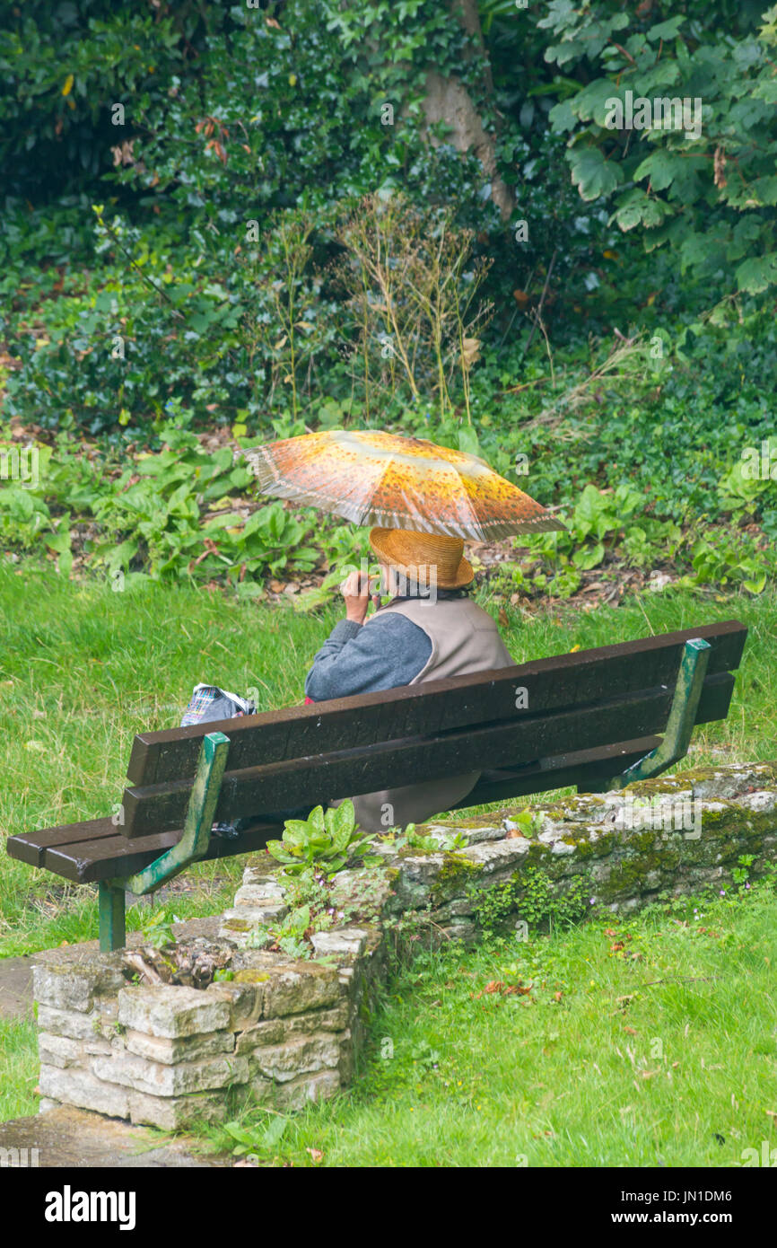 Bournemouth Dorset, Regno Unito. 29 Luglio, 2017. Regno Unito: meteo la pioggia non si ferma questa donna seduta in un parco sotto il suo ombrello per andare a mangiare qualcosa a Robert Louis Stevenson gardens Skerryvore in Westbourne, Bournemouth. Credito: Carolyn Jenkins/Alamy Live News Foto Stock