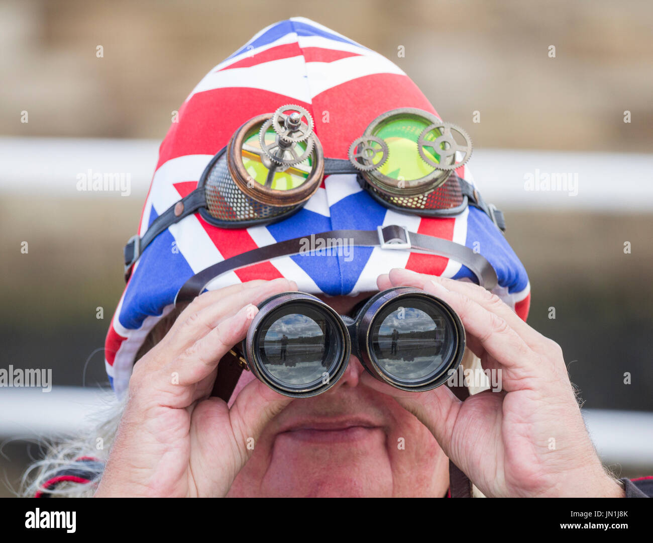 Uomo che guarda attraverso binocoli che indossa un casco piramistico dell'esercito britannico Union Jack: Allerta di soggiorno, patriottismo, Brexit ... concetto. Foto Stock