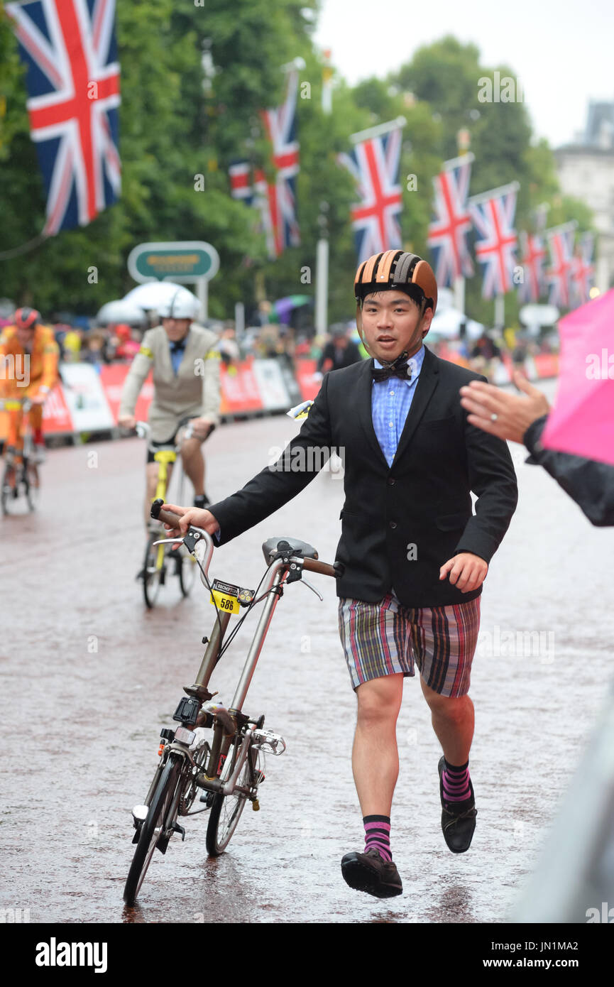 Londra, Regno Unito. 29 Luglio, 2017. Il 2017 Brompton Campionati del mondo. Ciclista gareggiato nella gara partendo con il dispiegamento del Brompton biciclette pieghevoli. I ciclisti possono entrare solo su una Brompton bici e non poteva indossare la lycra. Alcuni concorrenti indossavano i costumi per la gara. Un ciclista in esecuzione alla fine a causa di un pneumatico sgonfio. Andrew Steven Graham/Alamy Live News Foto Stock