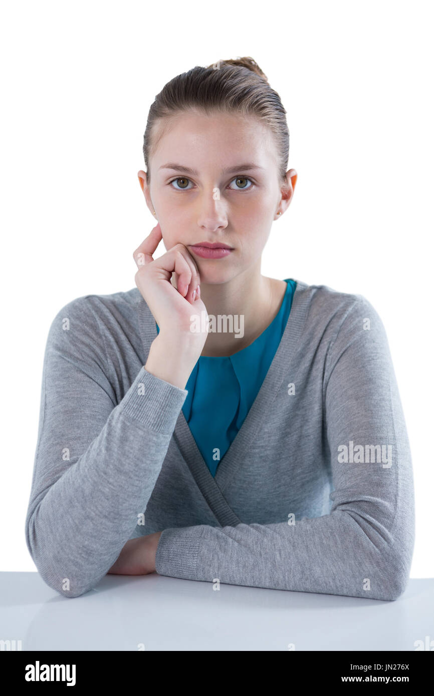 Ritratto di fiducioso ragazza adolescente seduto contro uno sfondo bianco Foto Stock