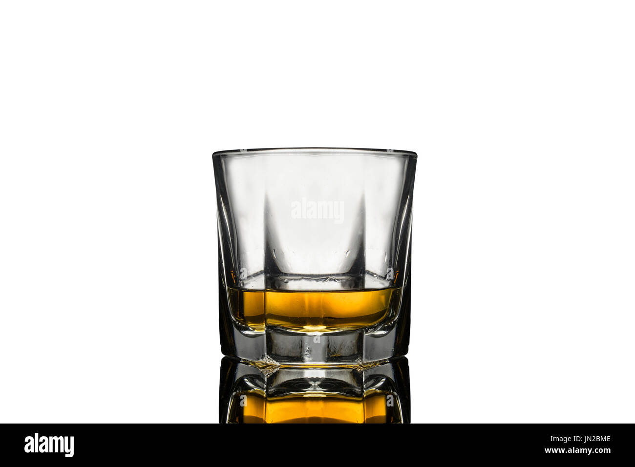 Il whiskey di vetro riempito con chiaro riflesso di seguito, sfondo bianco Foto Stock