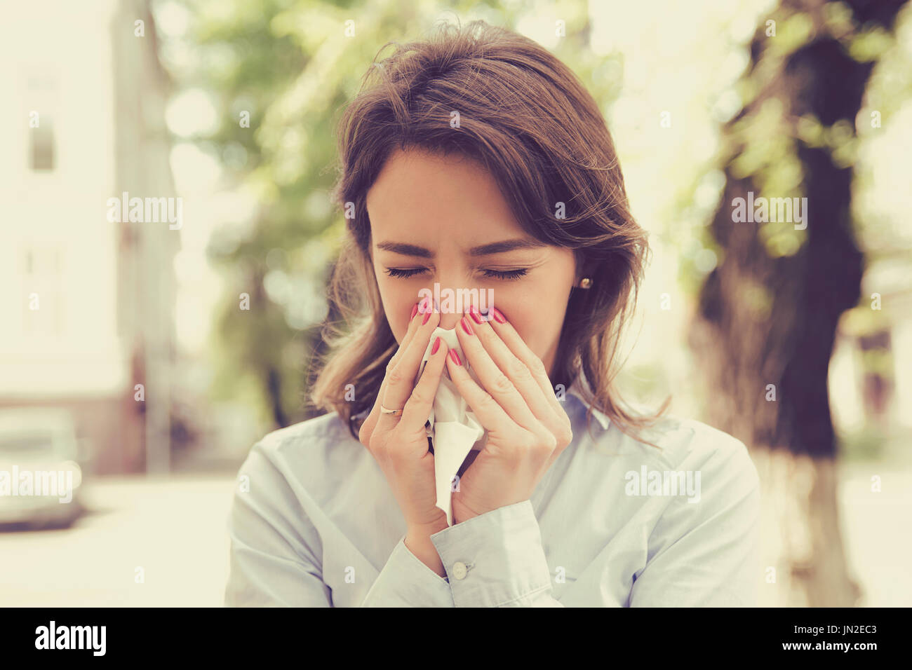 Donna con sintomi di allergia naso di soffiatura Foto Stock