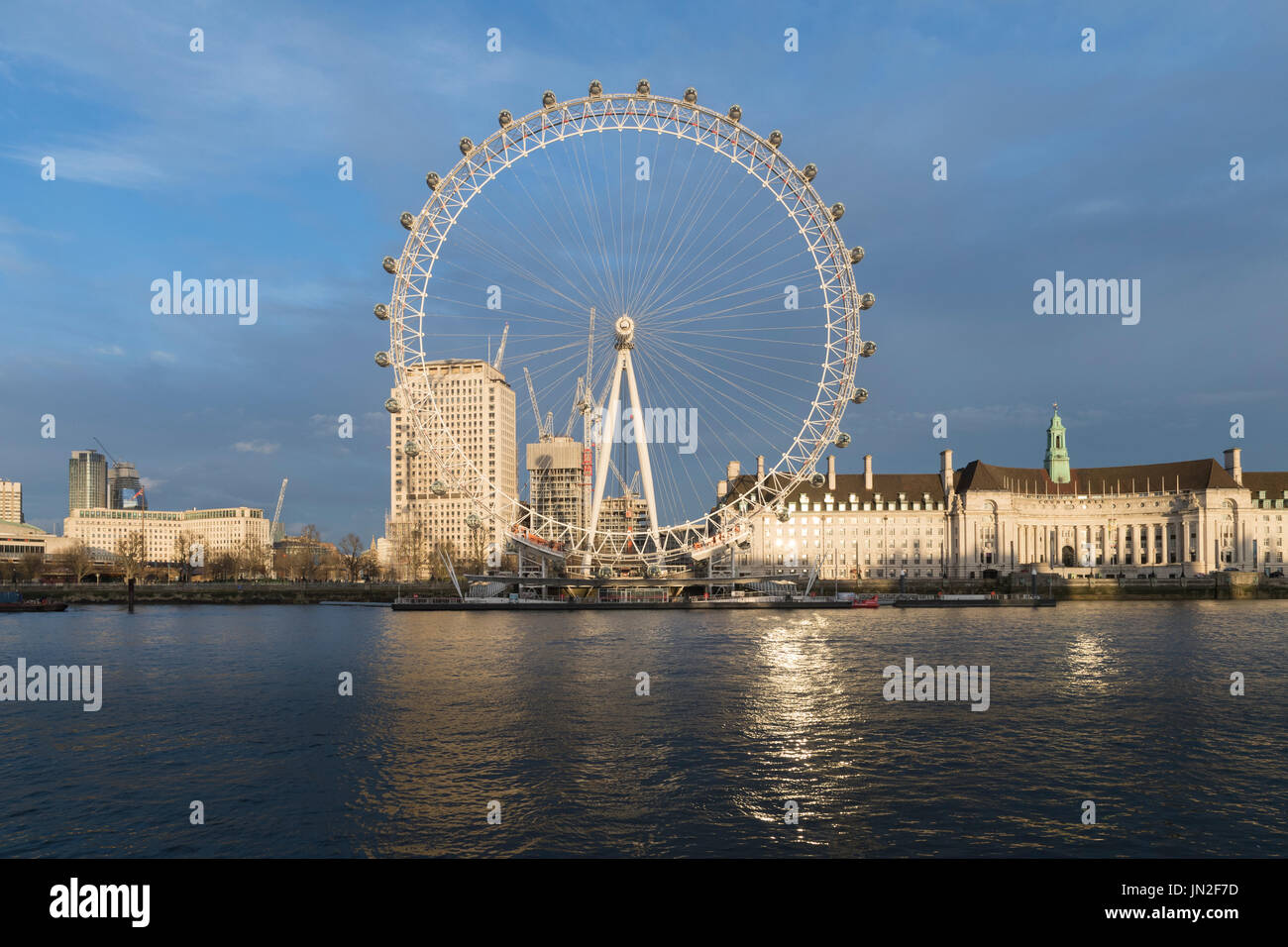 Il London Eye, noto anche come il Millennium Wheel fotografato dal lato nord del fiume Tamigi, con lavori di costruzione in corso in background. Foto Stock