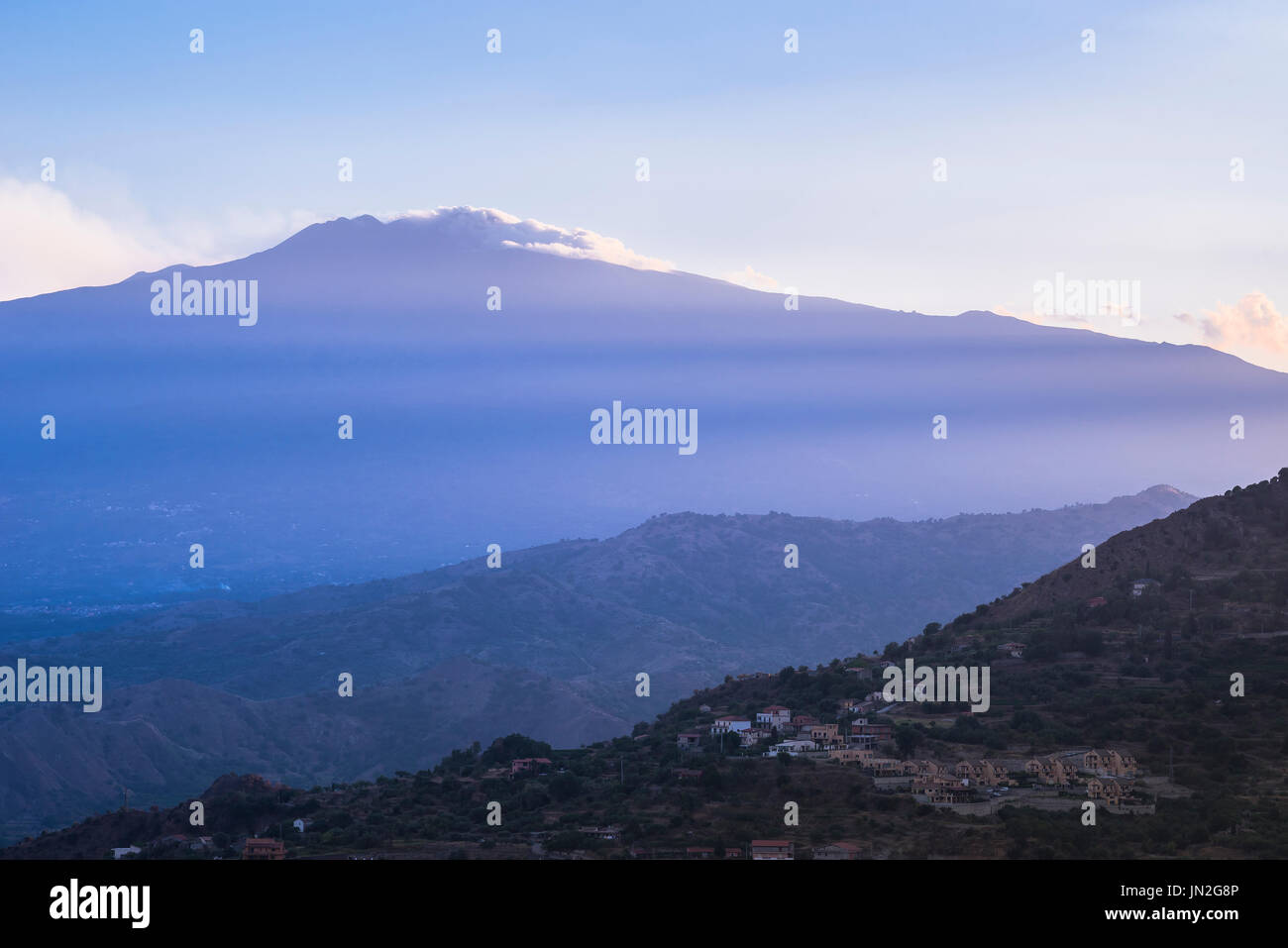 Etna Sicilia, vista dei raggi del tramonto che tramonta sull'Etna e sulle colline che circondano Taormina, Sicilia. Foto Stock