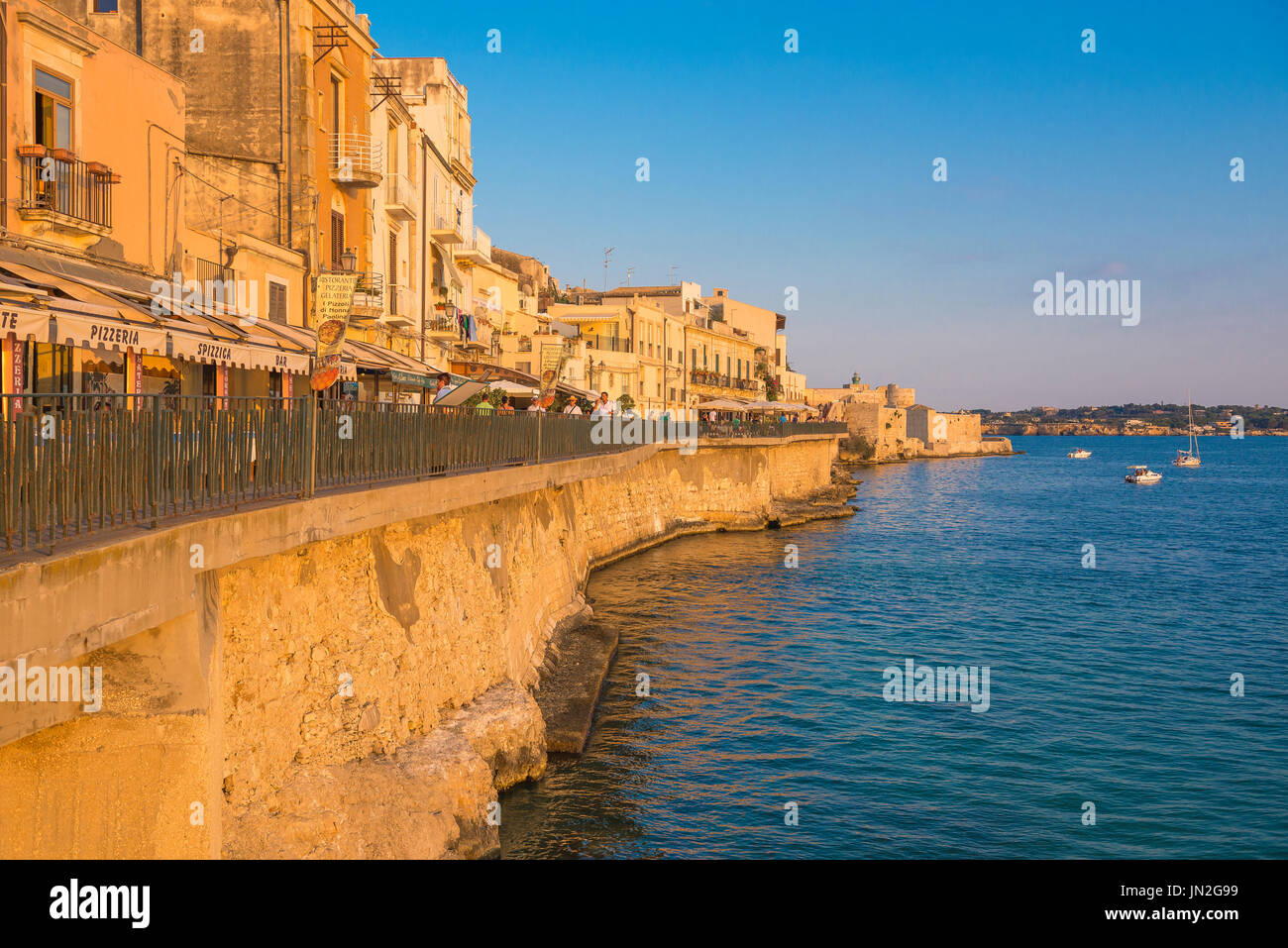 Siracusa Sicilia Harbour, mura sul mare - o Passeggio Adorno - sull isola di Ortigia che si affaccia sulla baia di Siracusa al tramonto, in Sicilia. Foto Stock