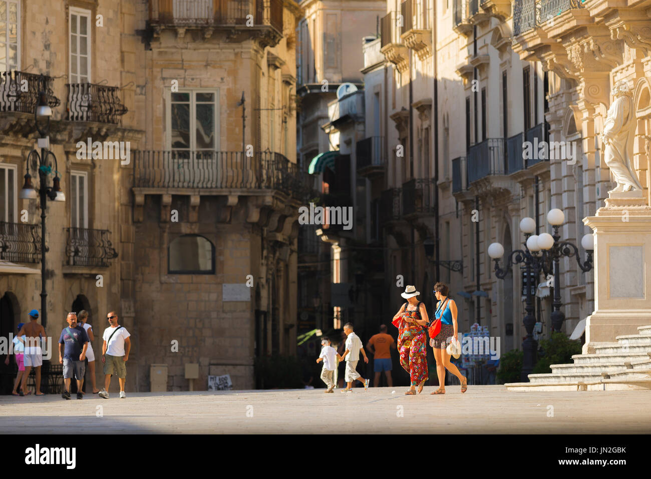 Turisti Sicilia, vista in estate dei turisti che passeggiando attraverso la Piazza del Duomo sull'Isola di Ortigia a Siracusa (Siracusa) Sicilia. Foto Stock