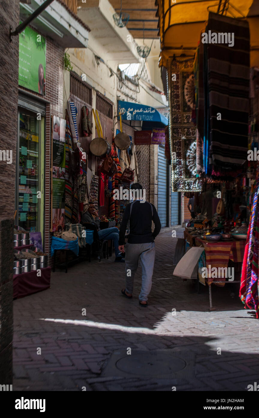 Un uomo marocchino nel souk, il mercato della Medina area della città vecchia di Tangeri, famosa per i suoi negozi di artigianato, bazar, spezie e colori brillanti Foto Stock